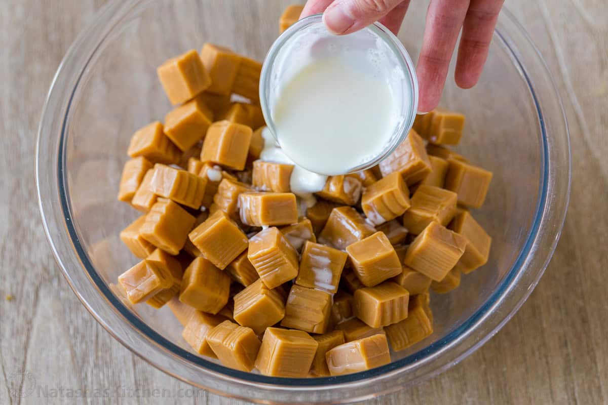 Melting caramels with cream for dipping caramel apples