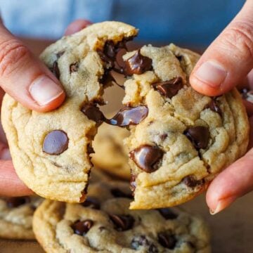 Breaking a soft chocolate chip cookie in half to show gooey morsels of chocolate